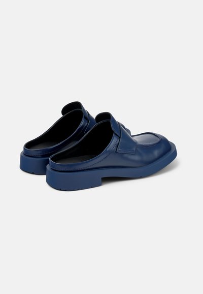 Navy blue leather clogs with a smooth texture, low heel, and open back design; features stitching accents along the top.