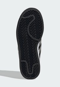 Black rubber shoe sole with a zigzag pattern, featuring white accent lines on the sides. Durable texture for traction.