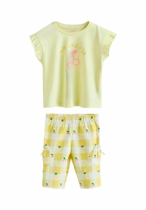 Yellow short-sleeve top with ruffled sleeves and "ma chérie" text and cherries graphic, paired with yellow checkered shorts with floral prints and pockets.