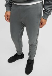 Grijze joggingsbroeken van zacht materiaal, met een slim fit, elastische tailleband, zijzakken en een subtiel logo op de dij.