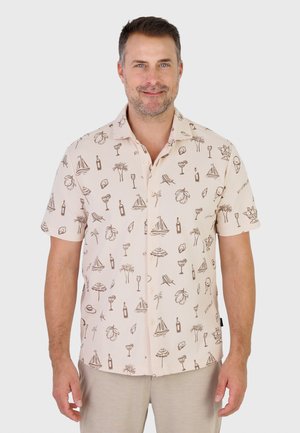 Mann trägt ein beigefarbenes, kurzärmeliges Hemd mit tropischen und sommerlichen Skizzen, steht vor einem schlichten Hintergrund.