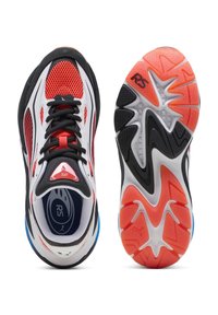 Sneaker atletica bianca, rossa e nera mostrata dall'alto e dalla vista della suola, con tomaia in rete, lacci neri e suola in gomma patterned con marchio RS.