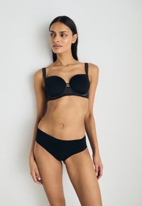 Black lingerie set featuring a padded bralette with lace trim and wide straps, paired with seamless high-waisted panties. Smooth fabric texture.