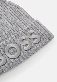 Gray ribbed knit beanie with folded cuff featuring raised satin-finish letters spelling "BOSS" on the cuff.