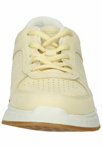 Light yellow sneaker with a smooth leather upper, perforated details, and white laces. Features a cushioned sole and light rubber outsole.