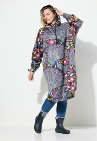Poncho de pluie coloré et à motifs dans des tons sombres, avec des designs floraux et de paon. Il dispose d'une capuche, de manches longues et de fentes sur les côtés pour plus de mobilité.