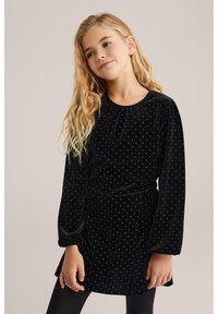 Melna velūra kleita ar garām piedurknēm, sudraba punktiņiem, sak gathered dekoltē un nedaudz izplešanos svārkiem. Valkāta ar melniem zeķbiksēm.