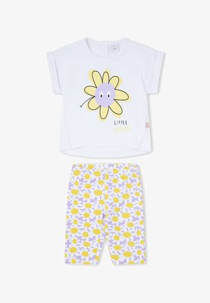 Camiseta blanca de niño pequeño con una flor amarilla y púrpura sonriente y texto "Pequeño amigo", combinada con pantalones estampados amarillos y púrpuras con flores.
