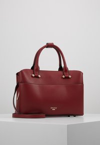 Rote Handtasche aus genarbtem Leder mit zwei Griffen, einem abnehmbaren Schulterriemen und goldfarbenen Akzenten. Verfügt über eine Fronttasche und gebrandete Metallbeschläge.