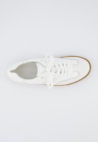 Sneaker in pelle bianca con lacci in cotone, dettagli perforati sulla punta e suola in gomma color sabbia. Design semplice con accenti curvi.