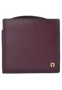 Burgundy leather wallet with a smooth texture, minimalist design, rounded edges, gold logo accent, and visible stitching along edges.