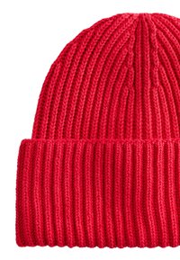 Red knitted beanie with a ribbed texture, featuring a fold-over cuff. The surface displays vertical lines and an even, tight weave throughout.