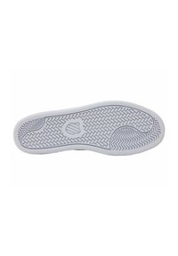 Semelle de sneaker blanche avec motif de grip texturé, dotée d'un élément de logo central et d'une forme arrondie, conçue pour l'adhérence et le soutien.