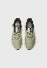 Light green athletic shoes with a breathable mesh upper, flat laces, and rubber sole. Features black accents and reflective detailing.