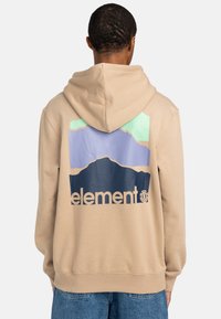Beige hoodie with a graphic design featuring mountains in purple and green. "Element" logo in navy is printed at the bottom. Soft texture.