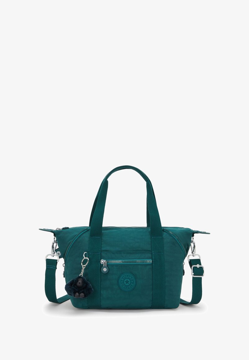 Teal fabric handbag with dual top handles, detachable shoulder strap, zip closure, front pocket, and furry keychain accessory.