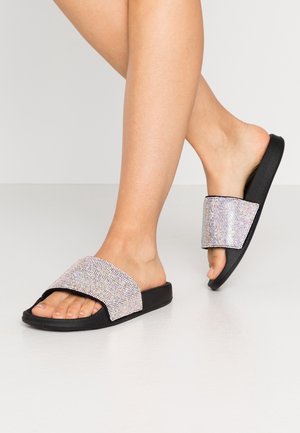 Sandali neri a fascia larga decorata con brillanti strass scintillanti, suola piatta e retro aperto per indossarli facilmente.