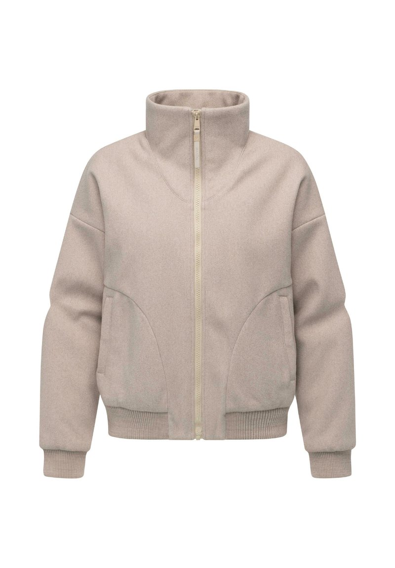 Beige ritsjack gemaakt van zachte stof, met een hoge kraag, ribgebreide manchetten en twee zijzakken met afgeronde randen.