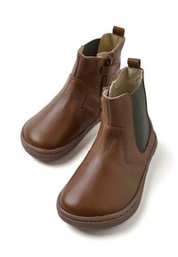 Botas de cuero marrón hasta el tobillo con paneles laterales elásticos, punta redondeada y suela acolchada. Detalles de costura visibles a lo largo de los bordes.