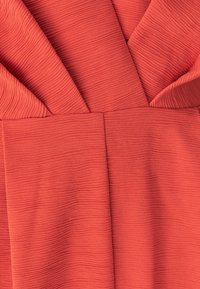 Primer plano de tejido de coral texturizado con estrías, con capas superpuestas que forman un patrón estructurado y plegado.