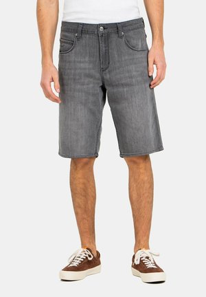 Graue Denim-Shorts mit geradem Schnitt, ausgestattet mit fünf Taschen, einem Knopfverschluss und kontrastierenden Nähten. Dazu werden braune Sneakers getragen.