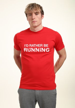 Czerwona bawełniana koszulka z białym napisem graficznym, na którym widnieje "WOLAŁBYM BIEGAĆ", z klasycznym krojem crew neck.