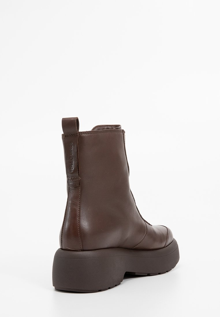 Brauner Leder-Stiefeletten mit runder Zehenform, robuster Plateausohle und einem Ziehriegel hinten. Glatte Textur mit minimalen Designdetails.