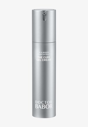 Flacon pompe cylindrique argenté étiqueté « 15 % Biogen Plant Extract The Cure Gel Cream » et « Doctor Babor » sur fond blanc.