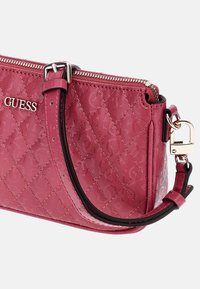 Borsa a tracolla sintetica rosa trapuntata con chiusura a zip, dettagli in logo argentato e tracolla staccabile. Presenta una rifinitura a contrasto nera.
