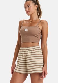 Bruine geribbelde crop top met witte bloemstickers, gecombineerd met beige shorts met bruine strepen. Elastische tailleband op de shorts.