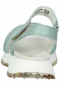 Sandali in pelle azzurro chiaro con suola bianca testurizzata, cinturino regolabile e base in gomma maculata. Design con rétro aperto per una facile vestibilità.