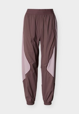 Bruine lichte joggerbroek met roze zijpanelen, een elastische tailleband en elastische boorden bij de enkels.