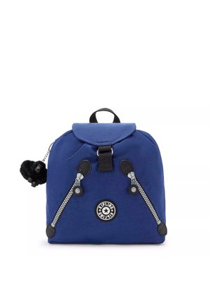 Zaino in nylon blu navy con una patta arrotondata, inserti con doppizia, accessori neri e un portachiavi a forma di scimmia pelosa attaccato. Logo circolare sul davanti.