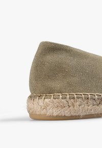 Espadrille-sko med en khaki kanvasoverdel, sål af jute-reb og en struktureret finish, med beige syninger langs sålen.