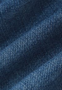 Denim o średnim do ciemnego niebieskiego koloru, z wyraźnym wzorem skośnym i lekko teksturowaną powierzchnią.