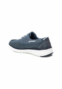 Zapatoscasuales masculinos en tela azul marino con suela acolchada blanca. Presentan costuras y cordones grises, y un diseño de punta redondeada.