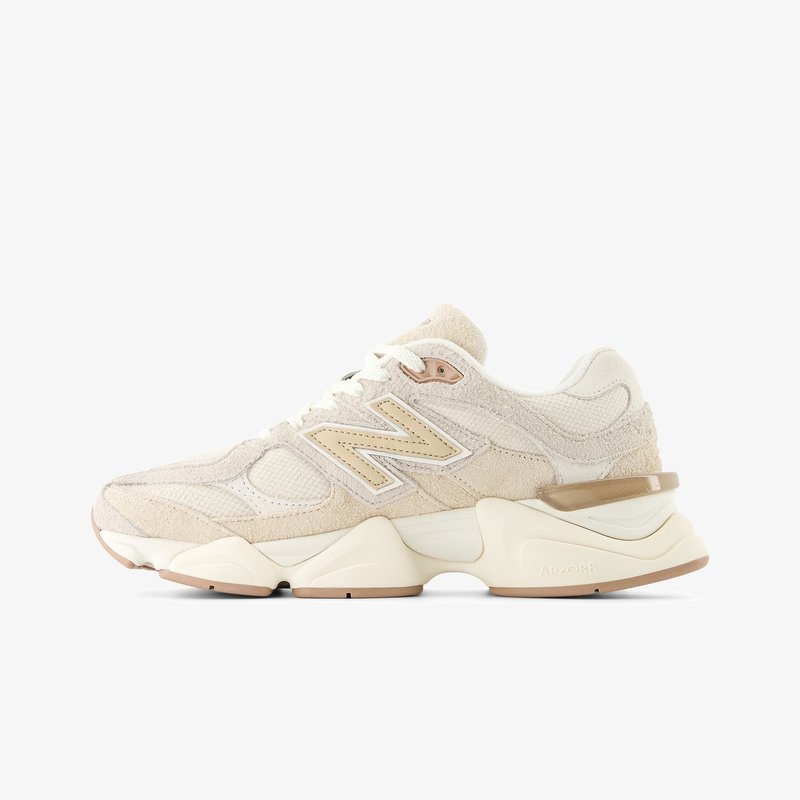 Scarpa sportiva beige e crema con tomaia in suede e mesh, suola spessa, logo "N" in evidenza e tallone imbottito per supporto.