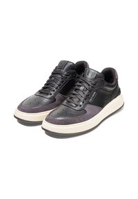 Černé kožené a semišové tenisky s nízkým střihem, které mají perforovanou špičku, texturované detaily a krémovou gumovou podrážku.