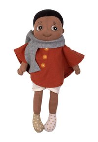 Miękka lalka z brązową skórą, krótkimi czarnymi włosami, ubrana w rdzawą pelerynę, szary szalik i niepasujące skarpetki w kropki.