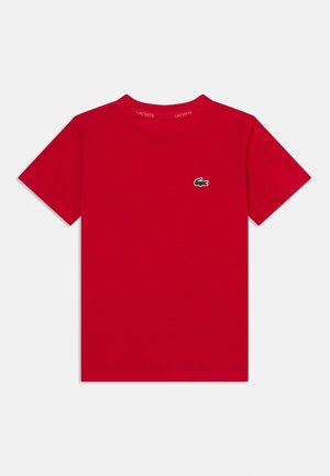 T-shirt rouge en coton à manches courtes avec un col rond et un petit logo crocodile vert sur le côté gauche de la poitrine.
