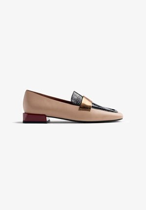 Bailarina con un cuerpo de cuero beige, parte delantera de charol negro con patrón de cocodrilo y un acento en tono dorado. Presenta un bajo tacón rojo cuadrado.