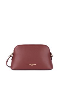 Borsa in pelle color borgogna con forma arrotondata, hardware dorato e logo impresso nella parte anteriore. Include una tracolla regolabile.
