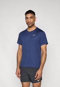 Μπλε ναυτικό μπλουζάκι Nike με στρογγυλή λαιμόκοψη, κοντά μανίκια και μικρό λευκό λογότυπο swoosh στο αριστερό στήθος. Λείο, ελαφρύ ύφασμα.