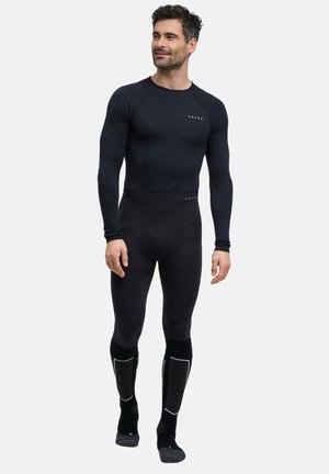 Conjunto de capa base térmica negra hecho de material suave. Parte superior de manga larga y pantalones ajustados, con detalles reflectantes en los calcetines.