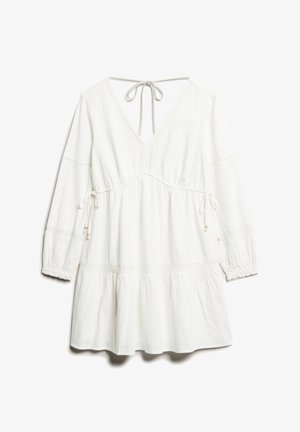 Witte jurk met een V-hals en een strik achter. Heeft lange mouwen, een geraffineerde taille met trekkoord, een gelaagde rok en delicate textuurdetails.