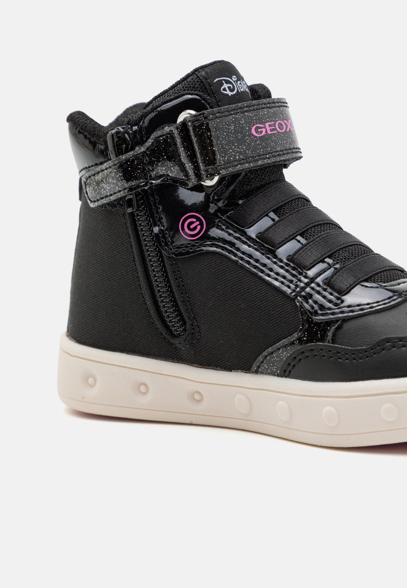 Sneaker nera alta con finitura in vernice lucida, cinturino regolabile, lacci e tessuto testurizzato; presenta un dettaglio del logo rosa e suola bianca.