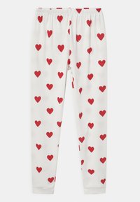 Hvite leggings med et helmønster av røde hjerter, med elastisk midje og tettsittende mansjetter ved anklene.