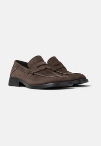 Brown suede loafers with a low black heel, featuring decorative stitching and a leather band across the upper for added detail.
