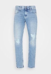 Jeans in denim azzurro chiaro con vestibilità rilassata, caratterizzati da due toppe strappate sulle ginocchia e un classico design a cinque tasche, con vita standard.