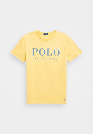 Camiseta amarilla de manga corta con cuello redondo, con texto "POLO RALPH LAUREN" en azul claro centrado y pequeño logo cerca del dobladillo inferior.
